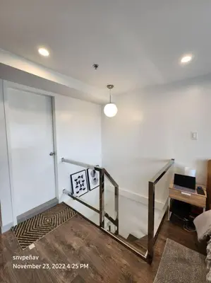 a room with a white wall with a stair case at Fort Victoria Tower B Condo BGC, Taguig City in Manila