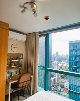a hotel room with a desk and a large window at BGC One Uptown Residence King Bed 3 min walk to malls and restaurants in Manila
