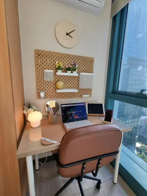 a desk with a laptop and a chair with a clock at BGC One Uptown Residence King Bed 3 min walk to malls and restaurants in Manila