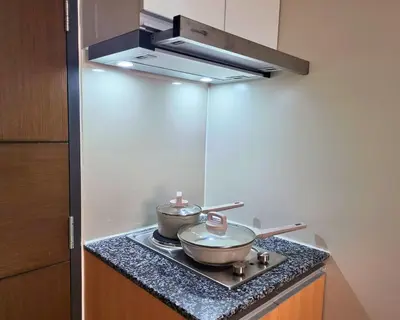 two pots and pans on a stove in a kitchen at BGC One Uptown Residence King Bed 3 min walk to malls and restaurants in Manila