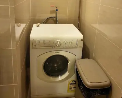 a small bathroom with a washing machine and a toilet at BGC One Uptown Residence King Bed 3 min walk to malls and restaurants in Manila