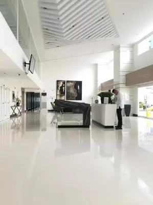 a man is standing in a large white lobby at 1BR Condotel with Balcony at SM Light Residences #LT01 in Manila