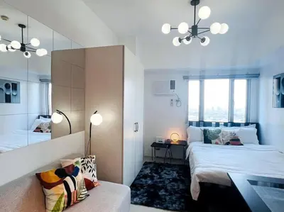 a bedroom with two beds and a mirror and a couch at 1BR Condotel with Balcony at SM Light Residences #LT01 in Manila