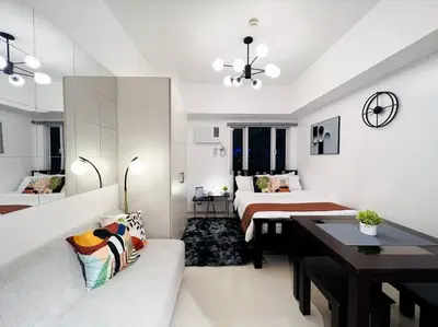 a room with two beds and a couch and a table at 1BR Condotel with Balcony at SM Light Residences #LT01 in Manila