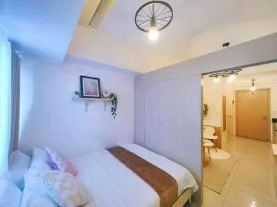 a bedroom with a bed and a clock on the ceiling at 1BR Condotel with Balcony at SM Light Residences #LT02 in Manila