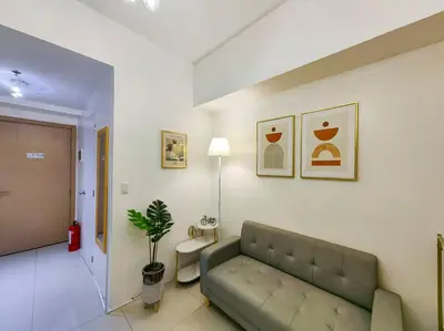 a living room with a green couch in a room at 1BR Condotel with Balcony at SM Light Residences #LT03 in Manila