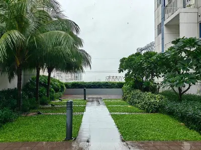 a walkway in a park with palm trees and a building at 1BR Condotel with Balcony at SM Light Residences #LT04 in Manila