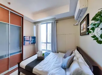a bedroom with a bed with a large window at 1BR Condotel Suite at Sunshine100 City Plaza #SS07 in Manila