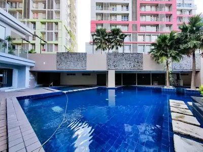 a large blue swimming pool in front of a building at 1BR Condotel Suite at Sunshine100 City Plaza #SS07 in Manila