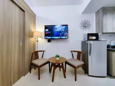 a kitchen with a table and chairs and a refrigerator at 1BR Condotel with Balcony at FAME Residences #FM01 in Manila