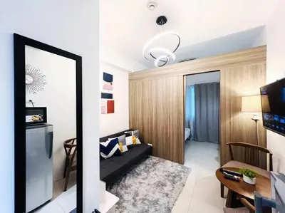 a living room with a black couch in a room at 1BR Condotel with Balcony at FAME Residences #FM01 in Manila