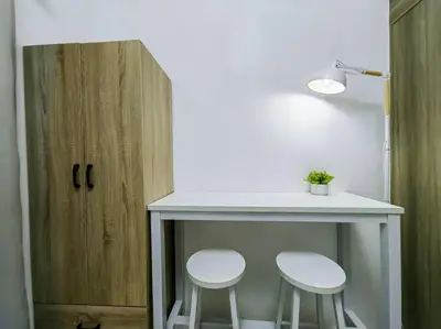 two white stools sitting under a counter with a table at 1BR Condotel with Balcony at FAME Residences #FM01 in Manila