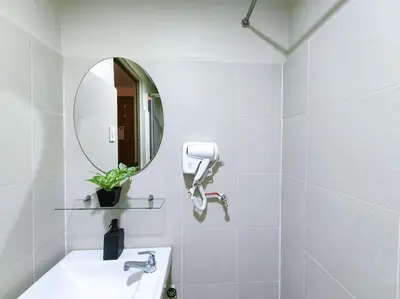 a white bathroom with a sink and a mirror at 1BR Condotel with Balcony at FAME Residences #FM03 in Manila