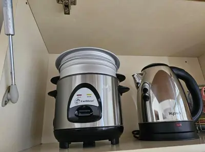 a slow cooker and a toaster on a kitchen counter at Sunshine 100 Plaza - Bright and cozy 1 bedroom with washer in Manila