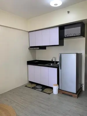 a kitchen with white cabinets and a refrigerator at Studio-type Apartment near Manila International Airport in Manila