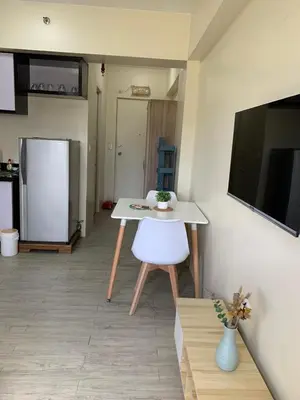 a kitchen with a white table and a refrigerator at Studio-type Apartment near Manila International Airport in Manila