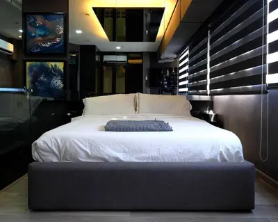 a bedroom with a large bed with white sheets at Casa Rica for adventurous fun - C Fort TB in Manila