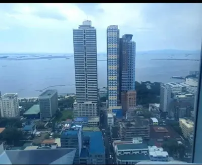 a city skyline with tall buildings and the ocean at 8 Adriatico Condotel Unit Facing Manila Bay in Manila