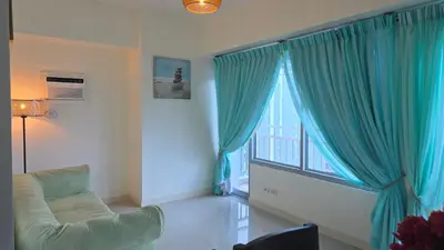 a living room with a couch and a large window at 8 Adriatico Condotel Unit Facing Manila Bay in Manila