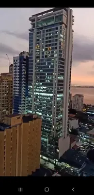 a tall building with lights on in a city at night at 8 Adriatico Condotel Unit Facing Manila Bay in Manila