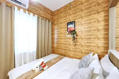 a bedroom with a wooden accent wall and a bed at 1BR Condotel with Balcony at FAME Residences #FM05 in Manila