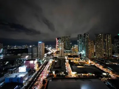 a city lit up at night with many tall buildings at 1BR Condotel with Balcony at FAME Residences #FM05 in Manila