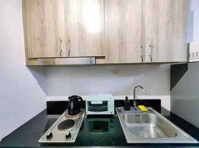 a kitchen counter with a sink and a microwave at 1BR Condotel with Balcony at FAME Residences #FM05 in Manila