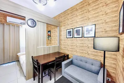 a room with a table and a chair and a bedroom at 1BR Condotel with Balcony at FAME Residences #FM05 in Manila
