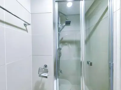 a shower with a glass door in a bathroom at 1BR Condotel with Balcony at FAME Residences #FM06 in Manila