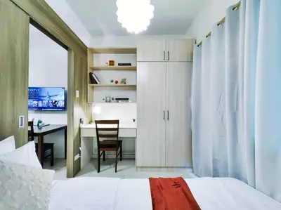 a bedroom with a bed and a desk with a chair at 1BR Condotel with Balcony at FAME Residences #FM06 in Manila