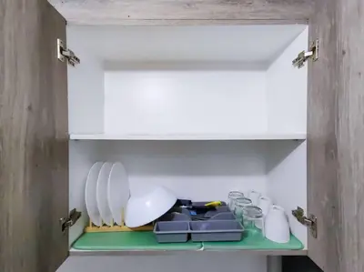 a cupboard with plates and dishes on a green shelf at 1BR Condotel with Balcony at FAME Residences #FM07 in Manila