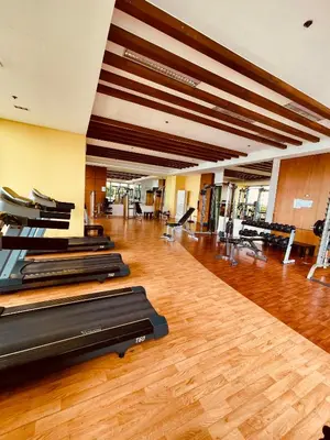 a gym with a row of treadmills in a room at Serene Condo Unit in Front of US Embassy in Manila