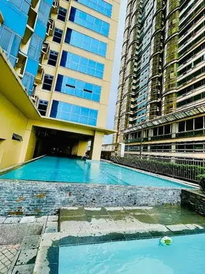 a swimming pool in front of two tall buildings at Serene Condo Unit in Front of US Embassy in Manila