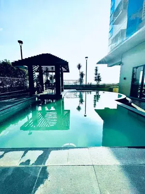 a swimming pool with a gazebo next to a building at Serene Condo Unit in Front of US Embassy in Manila