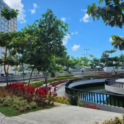 a park with a pond and trees and flowers at Deca Suites 946 in Manila