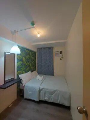 a small bedroom with a bed and a television at Deca Suites 946 in Manila