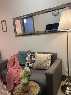 a living room with a couch and a mirror at Casa Del Castillo at Fame Residences near Megamall in Manila