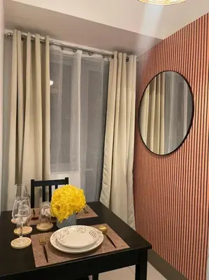 a dining room table with a mirror and flowers on it at Casa Del Castillo at Fame Residences near Megamall in Manila