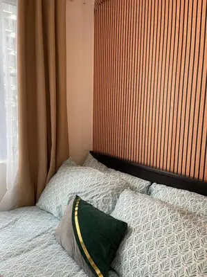 a bed with two pillows sitting next to a window at Casa Del Castillo at Fame Residences near Megamall in Manila