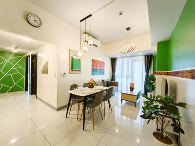 a dining room and living room with a table and chairs at BGC Uptown Parksuites 2BR Skyline View with Balcony and Bathtub in Manila