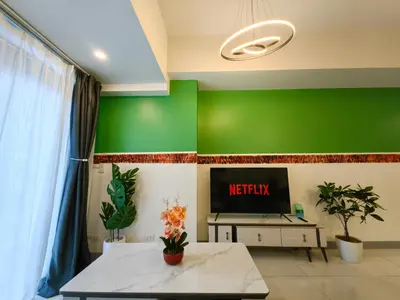 a living room with green walls and a tv at BGC Uptown Parksuites 2BR Skyline View with Balcony and Bathtub in Manila