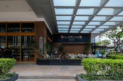 a building with a sign that reads wildour cafe at BGC Uptown Parksuites 2BR Skyline View with Balcony and Bathtub in Manila