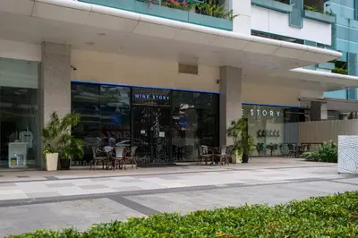 a store with tables and chairs outside of a building at BGC Uptown Parksuites 2BR Skyline View with Balcony and Bathtub in Manila