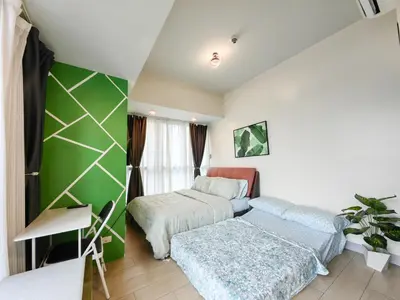 a bedroom with two beds and a green wall at BGC Uptown Parksuites 2BR Skyline View with Balcony and Bathtub in Manila