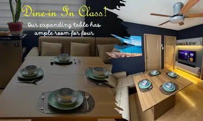 a living room with a table and a dining room at 2BR Italian-inspired Condo Unit, Balcony Pool View in Manila