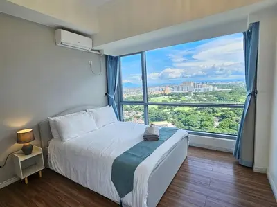 a bedroom with a bed and a large window at The Infinity Towers in BGC - Spectacular 2BR near Hight Street in Manila