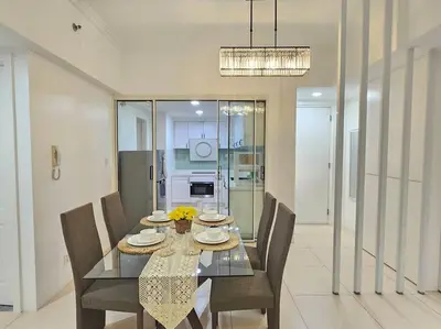 a dining room with a glass table and chairs at The Infinity Towers in BGC - Spectacular 2BR near Hight Street in Manila