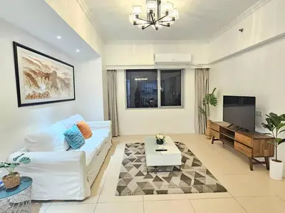 a living room with a white couch and a table at The Infinity Towers in BGC - Spectacular 2BR near Hight Street in Manila