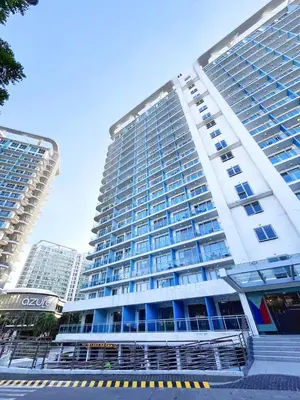 a large white building with blue windows in a city at Hope Stays in Manila