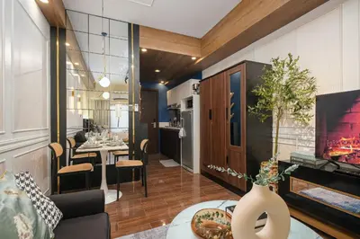 a living room with a fireplace and a kitchen at Air Residences, SMDC, Makati in Manila